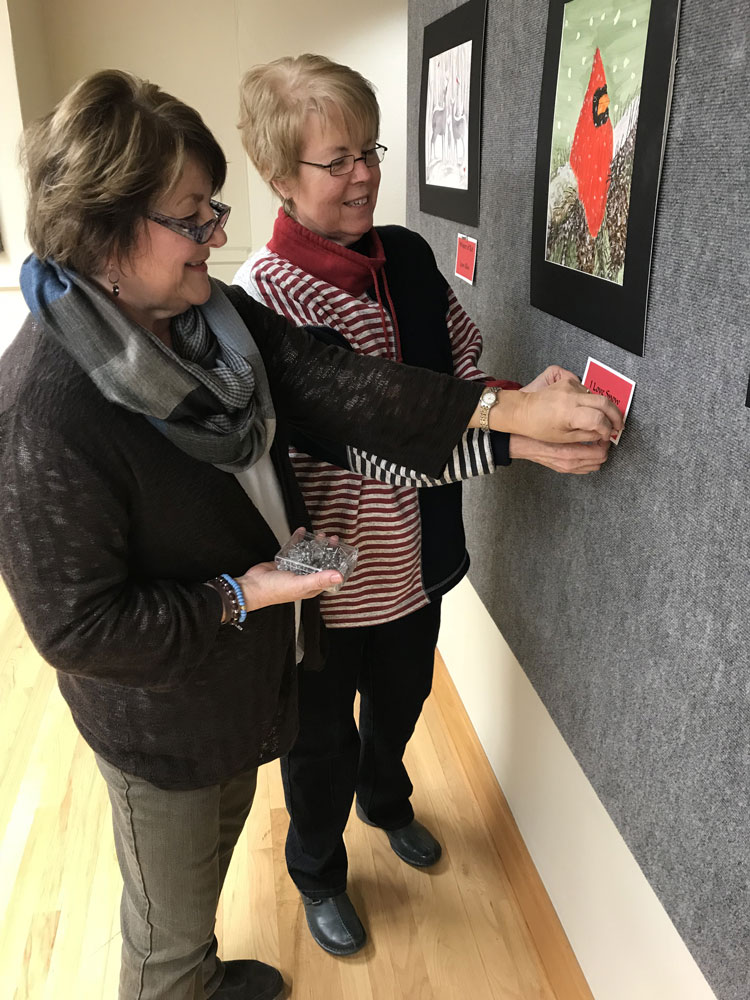 Photo Release: Linda Nichols, foreground, and Janice Miller, background, hang the Welcome to Cardinal Territory art display. The display is part of Joan Allen’s watercolor class from Chetopa and Parsons in the Labette Community College Hendershot Gallery. The show will be up until March 2. LCC Hendershot Gallery is located on the second floor of the main building and is free and open to the public.